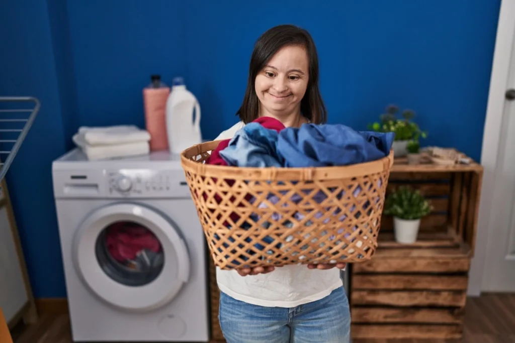 down syndrome women doing laundry and smiling