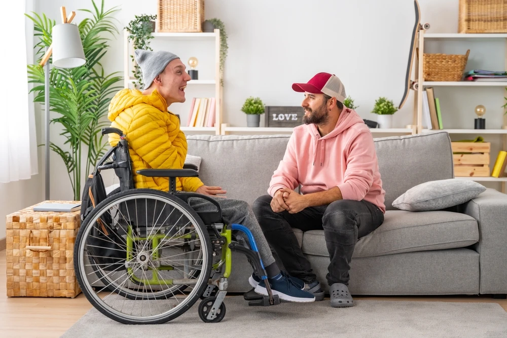 carer helping disabled boy on wheelchair